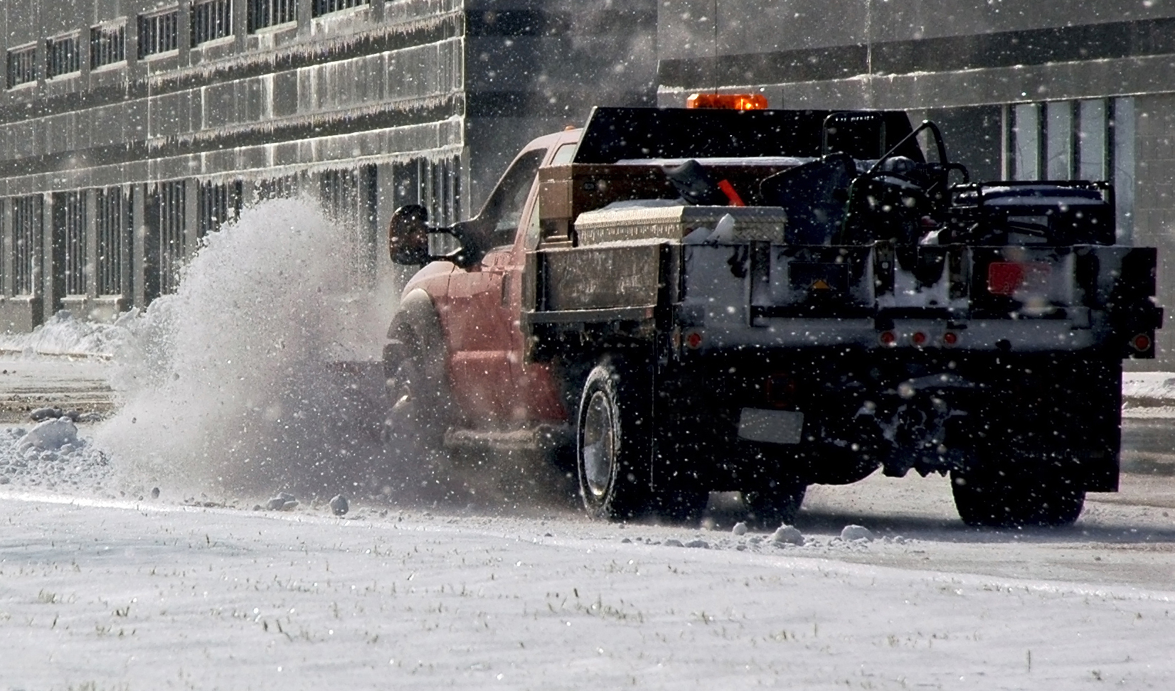 Snow plow cleaning up a commercial parking lot in Rockland County